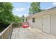 Wood back deck with views of trees and a door to the house; a red item sits on the deck at 3388 Hamilton Mill Rd, Buford, GA 30519
