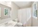 Cozy bathroom with a white shower curtain, toilet, sink, and a window at 3388 Hamilton Mill Rd, Buford, GA 30519