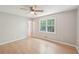 This bedroom features a large window that provides natural light, a ceiling fan, and wood flooring at 3388 Hamilton Mill Rd, Buford, GA 30519