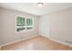 Bedroom featuring a window with natural light and view, light-colored walls, and light wooden floor at 3388 Hamilton Mill Rd, Buford, GA 30519