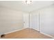 Cozy bedroom features light-colored walls, a wooden floor, and closet with full length louvered doors at 3388 Hamilton Mill Rd, Buford, GA 30519