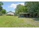 View of a shed with carport in the backyard with well-maintained grass and foliage on a sunny day at 3388 Hamilton Mill Rd, Buford, GA 30519