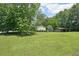 Beautiful landscape highlighting the large yard, mature trees, and a shed, perfect for outdoor enjoyment at 3388 Hamilton Mill Rd, Buford, GA 30519