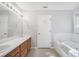 Bathroom featuring a double vanity and a framed mirror with a combination bathtub and shower at 360 N Oakland Circle, Mcdonough, GA 30253