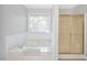 Bright bathroom featuring a bathtub, shower, and tile flooring at 360 N Oakland Circle, Mcdonough, GA 30253