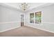 Well-lit dining area with a tray ceiling, chandelier, and large windows at 360 N Oakland Circle, Mcdonough, GA 30253