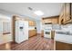 Eat-in kitchen with wood cabinets, white appliances, and wood-look flooring at 360 N Oakland Circle, Mcdonough, GA 30253