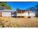 Back exterior of the home with a covered porch and steps down to the yard surrounded by mature trees at 280 Hitchcock Rd, Dallas, GA 30157