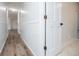 Hallway showcases white wood paneling that leads to a bright bathroom featuring unique flooring at 280 Hitchcock Rd, Dallas, GA 30157