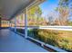 Covered front porch featuring white columns, painted floor, and natural backyard views at 280 Hitchcock Rd, Dallas, GA 30157