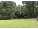 Backyard with a well-kept lawn and mature trees providing a serene setting at 3109 Windgate Dr, Buford, GA 30519