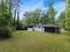 Expansive backyard with lush lawn, mature trees, and the home's exterior at 466 Thackery Sw Pl, Atlanta, GA 30311