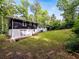 A large backyard with an expansive lawn, mature trees, and the home's exterior at 466 Thackery Sw Pl, Atlanta, GA 30311