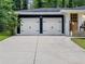 View of a two-car garage with a stained wooden door and a long driveway at 466 Thackery Sw Pl, Atlanta, GA 30311