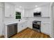 Well-lit kitchen with white cabinets, stainless appliances, and a farmhouse sink at 466 Thackery Sw Pl, Atlanta, GA 30311