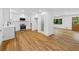 Open-concept kitchen featuring white cabinets, stainless steel appliances, and hardwood floors at 466 Thackery Sw Pl, Atlanta, GA 30311