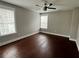 An airy bedroom featuring hardwood floors, natural light from two windows, and a modern ceiling fan at 1255 Plaza Sw Ave, Atlanta, GA 30310