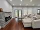 Inviting living room with a stone fireplace, hardwood floors, and a comfortable couch, bathed in natural light at 1255 Plaza Sw Ave, Atlanta, GA 30310