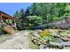 Spacious backyard featuring a wooden deck, rock lined pond with waterfall, and mature trees at 4751 Shay Ter, Buford, GA 30519