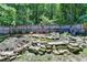 Wooded backyard featuring a rock-lined pond with waterfall feature and lush greenery at 4751 Shay Ter, Buford, GA 30519