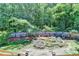 Lush backyard with wooden fence, rock bordered pond, decorative waterfall, and wishing well feature at 4751 Shay Ter, Buford, GA 30519