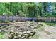 Backyard view of a rock-lined pond with a decorative waterfall feature and wooded backdrop at 4751 Shay Ter, Buford, GA 30519