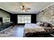 Bedroom with whitewashed brick accent wall, ceiling fan, wood floors, and natural lighting at 4751 Shay Ter, Buford, GA 30519