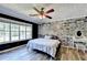 Bedroom with whitewashed brick accent wall, ceiling fan, and wood floors at 4751 Shay Ter, Buford, GA 30519