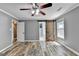 Bright bedroom featuring wood floors, a ceiling fan, and a unique sliding barn door to bathroom at 4751 Shay Ter, Buford, GA 30519