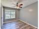 Bright bedroom with a large window, ceiling fan, and neutral color palette, complemented by stylish wood-look flooring at 4751 Shay Ter, Buford, GA 30519