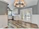 Stylish kitchen and dining area with white cabinets, stainless steel appliances, and modern lighting fixtures and glass doors at 4751 Shay Ter, Buford, GA 30519