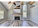 Spacious living room features a vaulted ceiling, modern fireplace, large windows offering natural light, and beautiful wood floors at 4751 Shay Ter, Buford, GA 30519