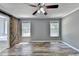 Serene bedroom with a rustic barn door leading to the bathroom and large windows providing plenty of natural light and ceiling fan at 4751 Shay Ter, Buford, GA 30519