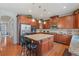 Stylish kitchen with cherry cabinets, granite countertops, stainless appliances, and an island with bar seating at 3476 Bridge Walk Drive, Lawrenceville, GA 30044