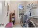Well-lit laundry room features a front loading washer and dryer and plenty of shelving space at 3476 Bridge Walk Drive, Lawrenceville, GA 30044
