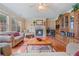 Bright living room with a fireplace, built-in shelving unit, and natural light from large windows at 3476 Bridge Walk Drive, Lawrenceville, GA 30044