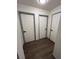 Hallway with three doors and wood-look flooring at 5526 Stoneleigh Ct, Stone Mountain, GA 30088