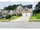 Traditional brick home with a manicured lawn, two-car garage, and inviting curb appeal at 665 Roxford Ln, Buford, GA 30518
