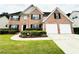 Charming two-story brick home showcasing a two-car garage and manicured landscaping at 665 Roxford Ln, Buford, GA 30518
