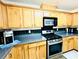 A well-lit kitchen featuring stainless steel appliances and wood cabinetry at 665 Roxford Ln, Buford, GA 30518