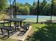 Community tennis court with a picnic table and benches for relaxing between matches at 665 Roxford Ln, Buford, GA 30518
