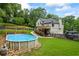 View of the backyard with an above ground pool, deck and pergola, with mature trees at 1301 Ficklen Church Way, Canton, GA 30114