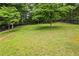 Expansive backyard with dark fencing around mature trees, offering an abundance of space for activities at 1301 Ficklen Church Way, Canton, GA 30114