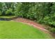 A large, lush backyard with tiered landscaping and a dark picket fence bordering mature trees at 1301 Ficklen Church Way, Canton, GA 30114