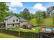 View of the backyard with an above ground pool, deck, pergola, and lush landscaping at 1301 Ficklen Church Way, Canton, GA 30114