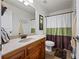 Well-maintained bathroom features a wood vanity, large mirror, and decorative shower curtain at 1301 Ficklen Church Way, Canton, GA 30114