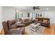 Inviting living room featuring hardwood floors, comfortable brown sofas, ceiling fan, and natural light at 1301 Ficklen Church Way, Canton, GA 30114