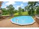 Above ground pool with a wooden deck and fence in a backyard with mature trees at 1301 Ficklen Church Way, Canton, GA 30114