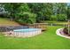 Above ground pool with a wooden deck and pergola in a fenced backyard with mature trees at 1301 Ficklen Church Way, Canton, GA 30114
