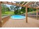 Above ground pool with a wooden deck and pergola in a fenced backyard with mature trees at 1301 Ficklen Church Way, Canton, GA 30114